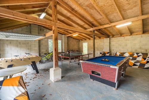 a room with a pool table and ping pong tables at Moulin de la Touche - Domaine Piscine in Plouguenast Langast