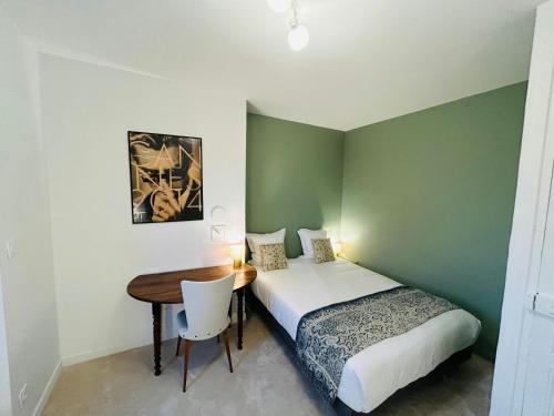 - une chambre avec 2 lits, un bureau et une table dans l'établissement Le Millésime Carnot Cathédrale, à Reims