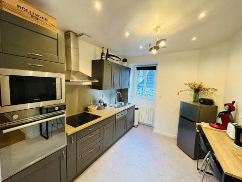 une cuisine avec des appareils en acier inoxydable et un comptoir dans l'établissement Le Millésime Carnot Cathédrale, à Reims