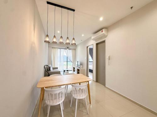 a kitchen and dining room with a wooden table and chairs at Iconic Regency by Li in Gelugor