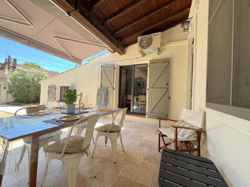 une salle à manger avec une table et des chaises sur un patio dans l'établissement La Montplaisir Maison jardin Arles, à Arles