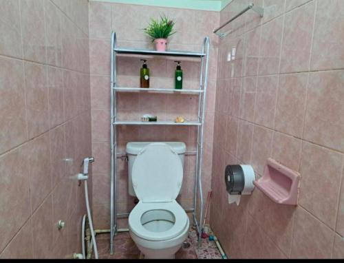 a bathroom with a toilet and two bottles of wine at house 1 for 6 paxs whole house 3 beds in Hat Yai