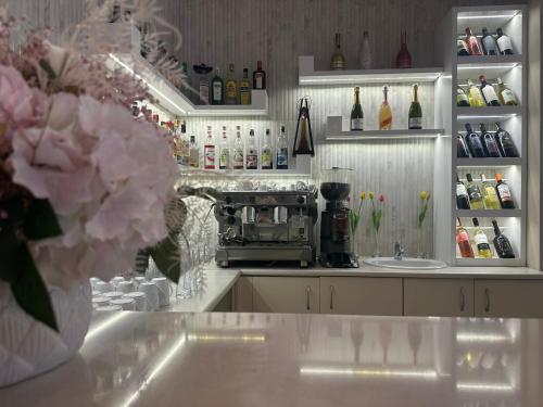 a kitchen with a counter with a coffee maker and flowers at Hotel Dudek in Mniów