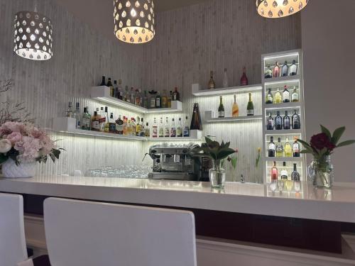 a bar with two white shelves with bottles of wine at Hotel Dudek in Mniów