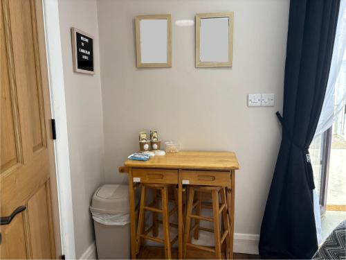 Droichead an BhuitléaraighにあるPrivate Detached Small Bedroom and Bathroom Only- This is not an apartment- No clothes storage- no cooking facilitiesの木製のテーブルとスツールが置かれた小さなバスルーム