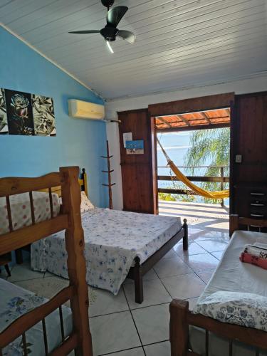 a bedroom with two bunk beds and a sliding glass door at Pousada Popeye in Praia de Araçatiba