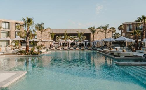 a pool at a hotel with chairs and umbrellas at Bonito Ibiza by O Beach - New Opening 2025 in San Antonio
