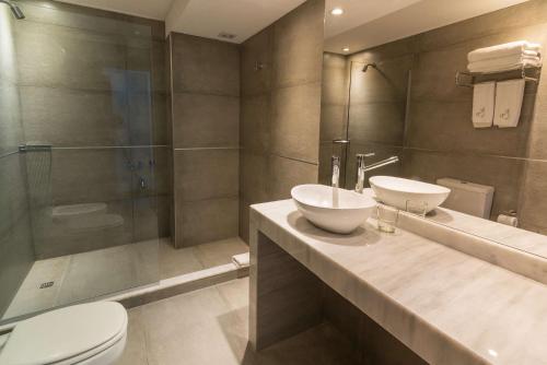 a bathroom with a sink and a toilet and a shower at Rincón del Duende Resort y Spa de Mar in Mar de las Pampas