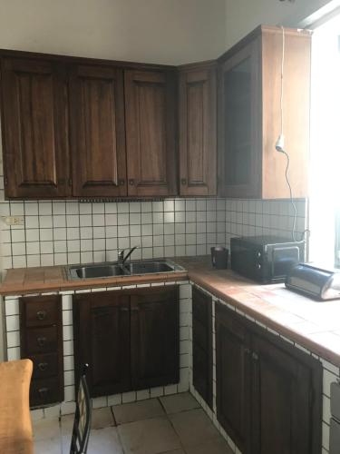 a kitchen with wooden cabinets and a sink at Il Cortile Di San Lazzaro Lecce in Lecce