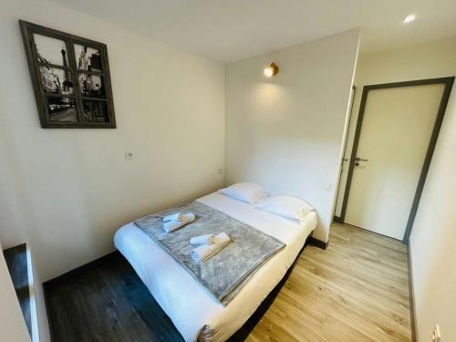 une chambre avec un lit avec deux serviettes dessus dans l'établissement La Cour Barbatre Calme, à Reims