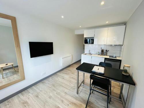 un salon avec une table de salle à manger et une cuisine dans l'établissement La Cour Barbatre Calme, à Reims