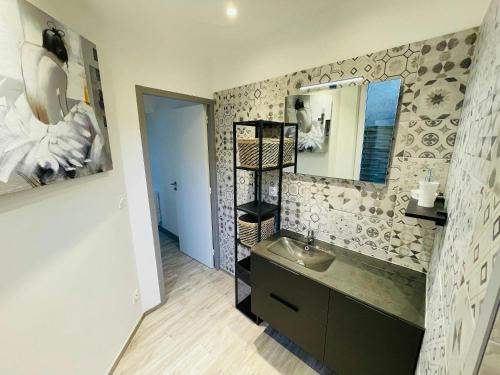 une salle de bain avec un lavabo et un miroir dans l'établissement La Cour Barbatre Calme, à Reims