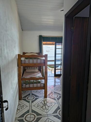 a room with a bunk bed on a tile floor at Pousada Popeye in Praia de Araçatiba