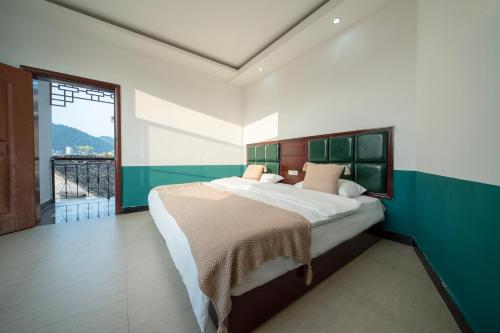 a bedroom with a large bed and a large window at 云起山居庭院观景民宿 in Fenghuang