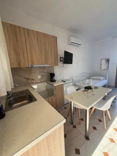 a kitchen with a sink and a table with chairs at PetrosStudios in Néa Epídhavros
