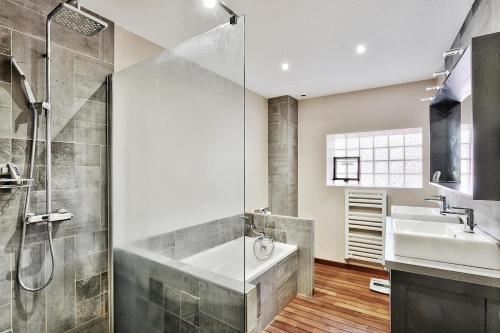 a bathroom with a tub and a sink and a shower at Le gite du pilot in Soucieu-en-Jarrest