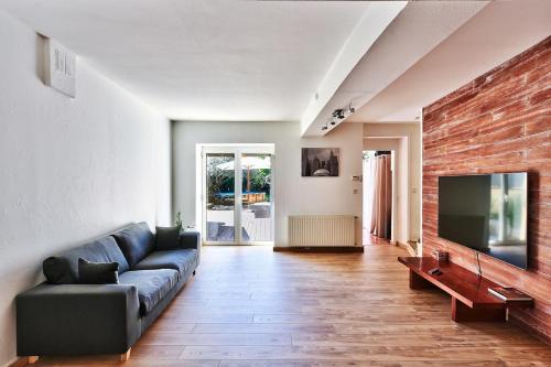 a living room with a couch and a flat screen tv at Le gite du pilot in Soucieu-en-Jarrest