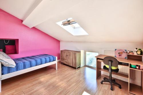 a bedroom with pink walls and a desk and a bed at Le gite du pilot in Soucieu-en-Jarrest