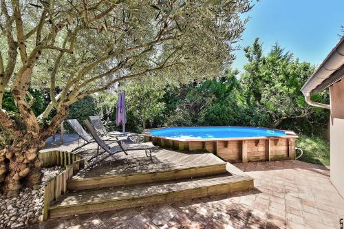 a swimming pool in a yard next to a tree at Le gite du pilot in Soucieu-en-Jarrest
