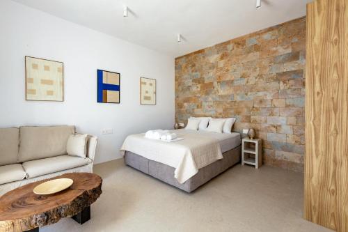 una camera da letto con un letto e un divano di Kyma & Anemos Suites a Naoussa