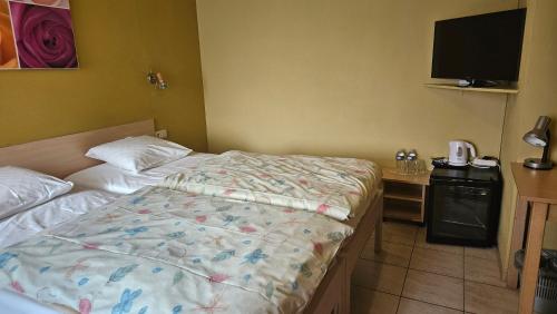 a bedroom with a bed and a desk with a television at Hostellerie Daiseldaele in Dadizele