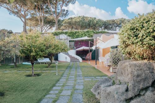 a garden with a stone path leading to a house at Villa Conchiglia blu con piscina in Ischia