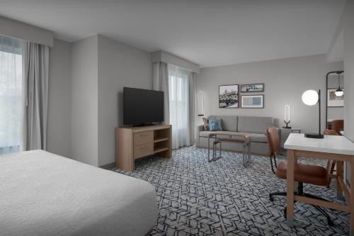 a hotel room with a bed and a desk and a television at Homewood Suites by Hilton Princeton in Princeton
