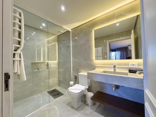 a bathroom with a toilet and a sink and a shower at Pousadinha Campos in Campos do Jordão