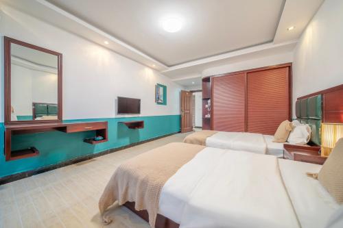 a hotel room with two beds and a tv at 云起山居庭院观景民宿 in Fenghuang