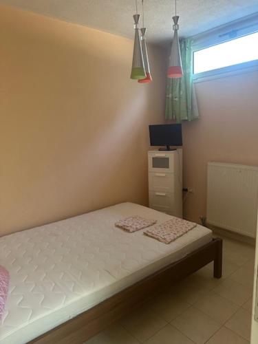 a bedroom with a bed and a tv and a window at MELIA Holidays & Living in Epanomi