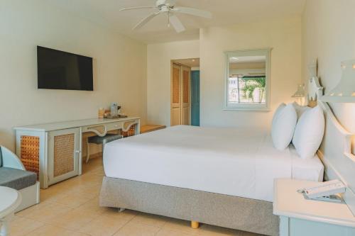 a bedroom with a white bed and a desk at Iberostar Waves Costa Dorada - All Inclusive in San Felipe de Puerto Plata