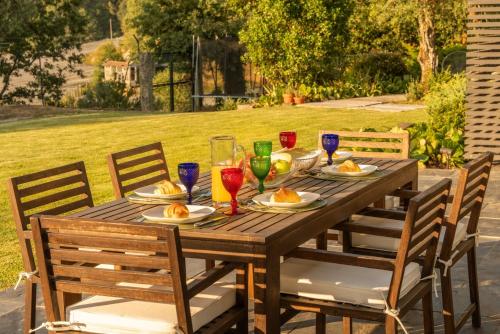 a wooden table with plates of food and wine glasses at Stars View by Portugal Active in Fafe