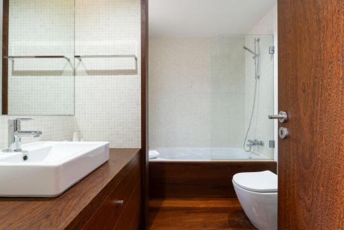 a bathroom with a sink and a tub and a toilet at Stars View by Portugal Active in Fafe