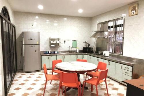 a kitchen with a table and chairs and a refrigerator at Cozy Johor Bahru Home with Family Room and unblock balcony View in Johor Bahru