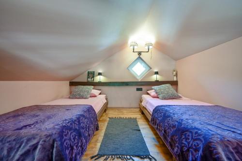 two beds in a room with blue comforter at 3 Bed Villa-Sleeps 8-Private pool-Mountain Views in Kuzminec