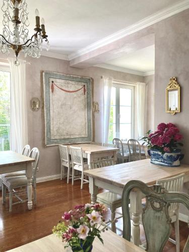 a dining room with tables and chairs and a painting on the wall at Landhaus Hohe Buchen in Plön