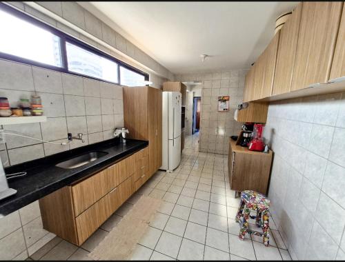 a small kitchen with a sink and a refrigerator at Sunflower in João Pessoa