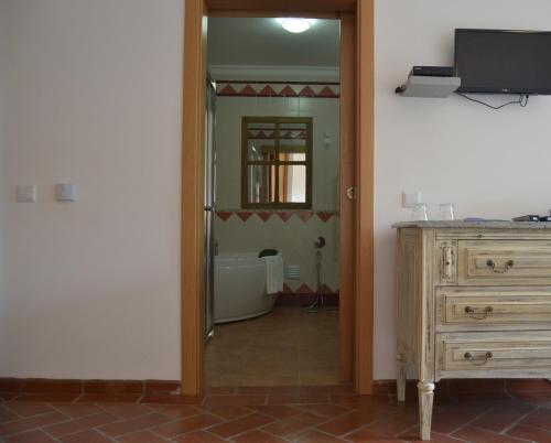 a hallway with a mirror and a dresser in a room at Quinta dos Tesouros in São Brás de Alportel