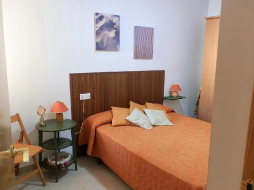 a bedroom with a bed and two tables with lamps at Vacaciones ideales: apto con piscina, cerca del mar, wifi, aire opcional, admite mascotas, playa perros - ES-184-11 in Riumar