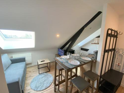 ベルフォールにあるLogement Neuf Cosy avec Espaces Communs Premium 22の小さなリビングルーム(テーブル、階段付)