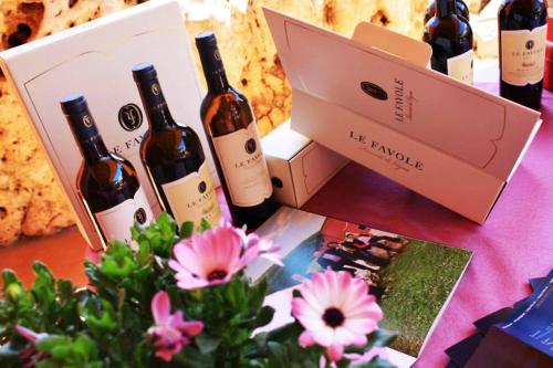 a table with bottles of wine and a book and flowers at Le Favole Agriturismo in Sacile