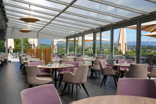 a restaurant with tables and chairs and windows at Thalazur Antibes - Hôtel & Spa in Antibes