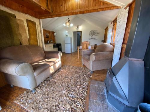 a living room with two couches and a kitchen at Nullarbor Cottages in Magaliesburg