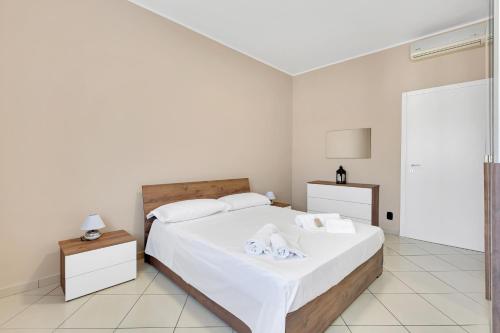 a bedroom with a bed with white sheets and towels at Casa Torino - Rho Fiera Stay in Rho