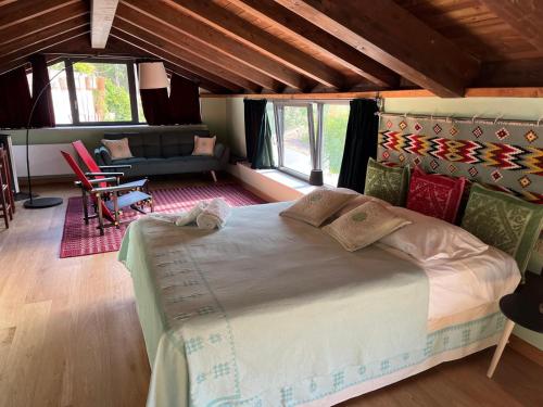 a bedroom with a large bed and a living room at Casa Ziranu Sa Domo e su Cantaru in Orani