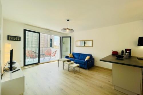 un salon avec un canapé bleu et une table dans l'établissement charming new flat with balcony, à La Rochelle