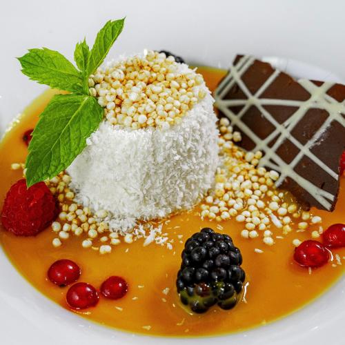 a dessert with powdered sugar and berries on a plate at Gartenhotel Maria Theresia in Hall in Tirol