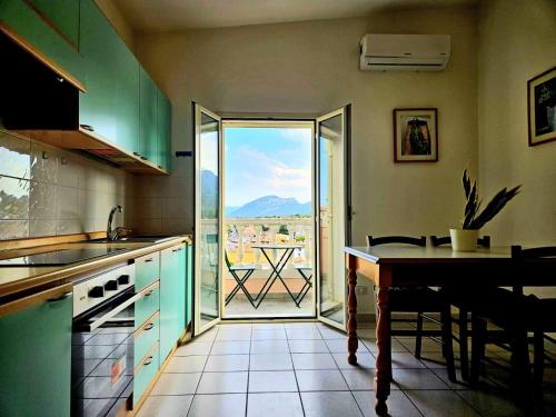 a kitchen with a table and a view of a patio at Bentos - Appartamenti in centro a Orosei in Orosei