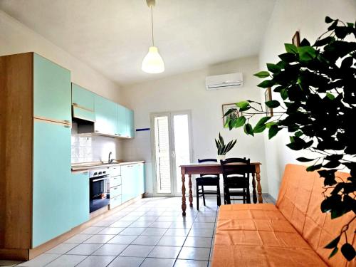 a kitchen and dining room with a table and a plant at Bentos - Appartamenti in centro a Orosei in Orosei