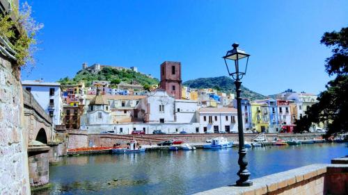 a street light next to a river with buildings at Casa delle Sirene e del Polpo in Bosa